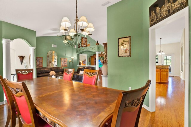 4571 Abaco Dr, Tavares, FL 32778 - dining room featuring a chandelier, wood finished floors, ornate columns, baseboards, and high vaulted ceiling