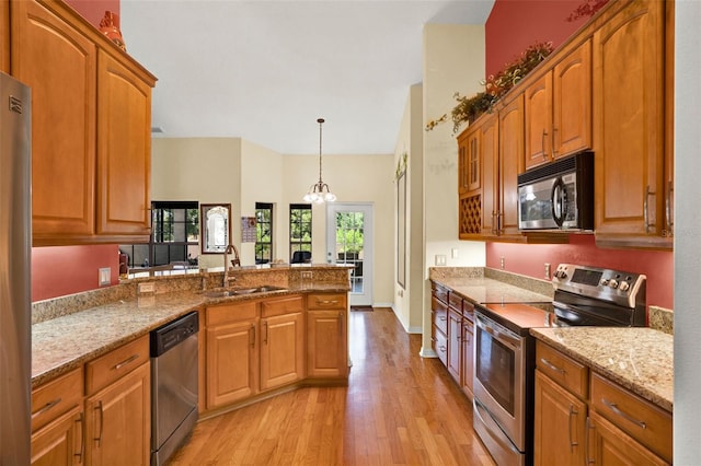 4571 Abaco Dr, Tavares, FL 32778 - kitchen with appliances with stainless steel finishes, a sink, light wood-style flooring, a peninsula, and light stone countertops