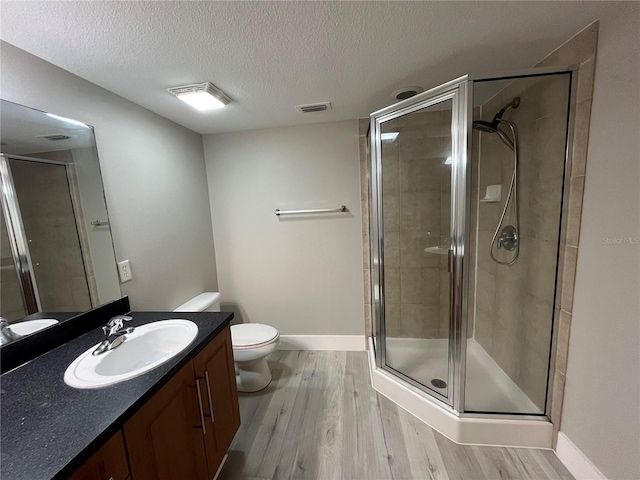 155 N Pearl Lake Cswy Unit 104, Altamonte Springs, FL 32714 - full bathroom featuring wood finished floors, toilet, vanity, a stall shower, and a textured ceiling