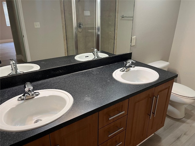 155 N Pearl Lake Cswy Unit 104, Altamonte Springs, FL 32714 - bathroom with toilet, double vanity, wood finished floors, and a shower stall