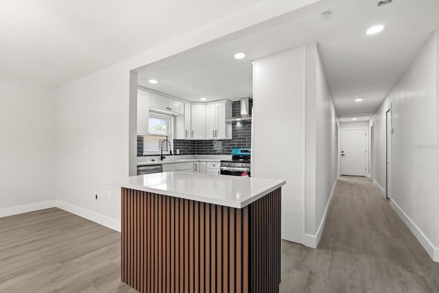 612 Florida Ave, Saint Cloud, FL 34769 - kitchen featuring stainless steel electric range oven, wall chimney range hood, light wood-style flooring, light countertops, and white cabinetry