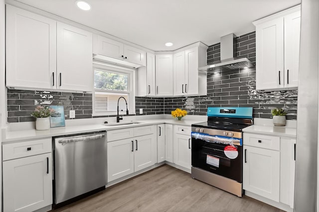 612 Florida Ave, Saint Cloud, FL 34769 - kitchen with appliances with stainless steel finishes, wall chimney exhaust hood, a sink, light countertops, and recessed lighting