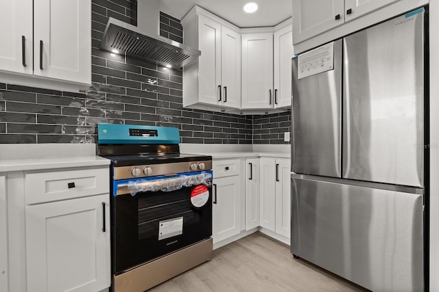 612 Florida Ave, Saint Cloud, FL 34769 - kitchen featuring stainless steel appliances, wall chimney range hood, light countertops, white cabinetry, and recessed lighting