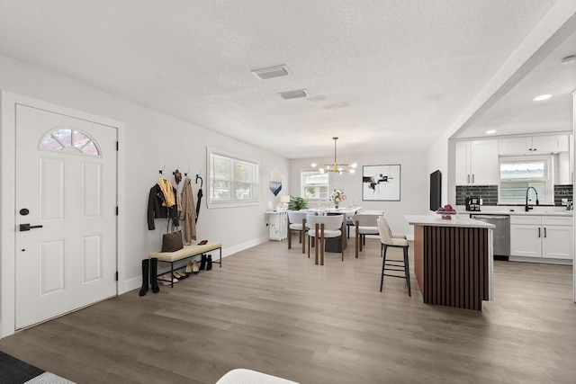 612 Florida Ave, Saint Cloud, FL 34769 - entrance foyer featuring light wood-type flooring, a chandelier, baseboards, a textured ceiling, and recessed lighting