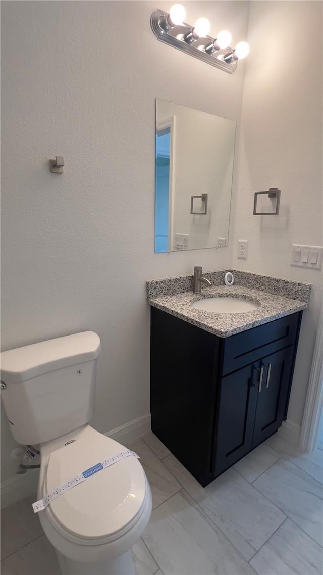 3315 W Montgomery Ln, Citrus Springs, FL 34433 - half bath with baseboards, toilet, vanity, and marble finish flooring