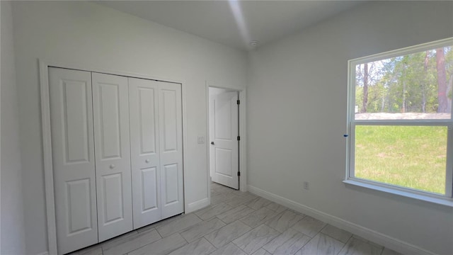 3315 W Montgomery Ln, Citrus Springs, FL 34433 - unfurnished bedroom with a closet, multiple windows, and baseboards