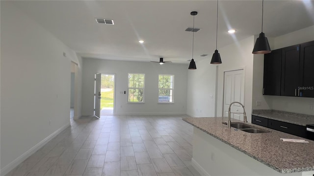 3315 W Montgomery Ln, Citrus Springs, FL 34433 - kitchen with a sink, dark cabinets, baseboards, recessed lighting, and decorative light fixtures