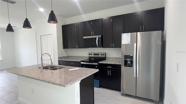 3315 W Montgomery Ln, Citrus Springs, FL 34433 - kitchen with appliances with stainless steel finishes, a sink, light marble finish floors, dark cabinetry, and a center island with sink