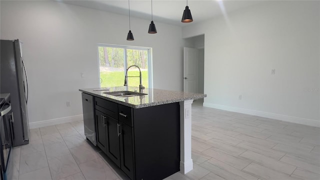 3315 W Montgomery Ln, Citrus Springs, FL 34433 - kitchen featuring a sink, dark cabinets, a center island with sink, light stone counters, and appliances with stainless steel finishes