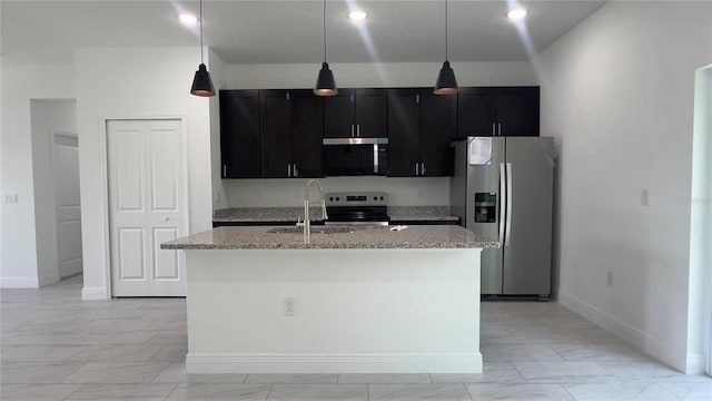 3315 W Montgomery Ln, Citrus Springs, FL 34433 - kitchen featuring stainless steel appliances, a sink, a center island with sink, dark cabinetry, and light stone countertops