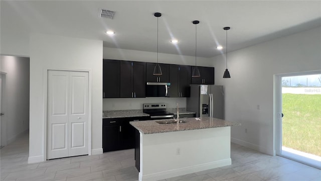 3315 W Montgomery Ln, Citrus Springs, FL 34433 - kitchen featuring stainless steel appliances, dark cabinets, a kitchen island with sink, light stone countertops, and decorative light fixtures