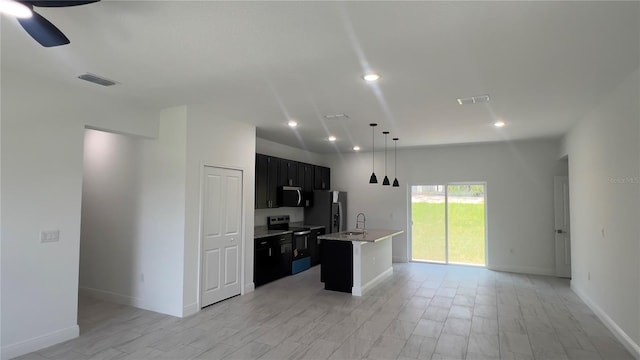 3315 W Montgomery Ln, Citrus Springs, FL 34433 - kitchen featuring stainless steel appliances, open floor plan, light countertops, dark cabinets, and an island with sink