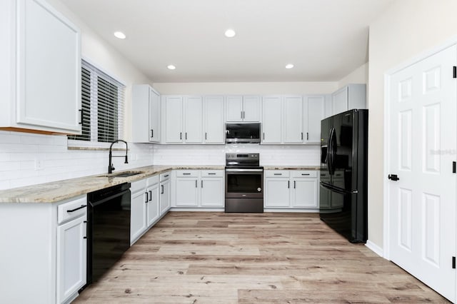 309 Black Springs Ln, Winter Garden, FL 34787 - kitchen with black appliances, a sink, tasteful backsplash, light stone counters, and light wood-style floors