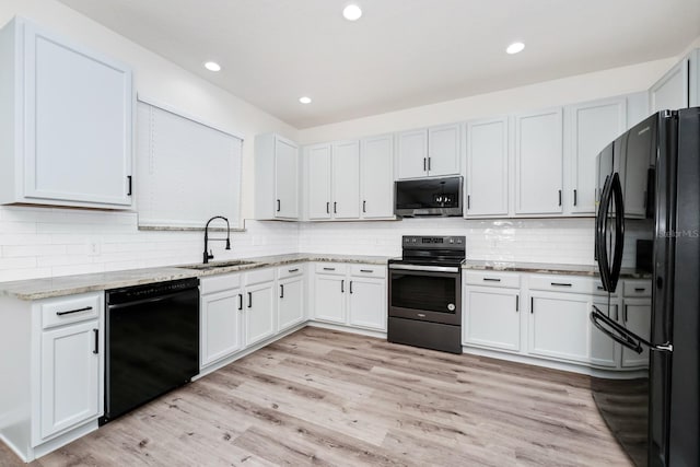 309 Black Springs Ln, Winter Garden, FL 34787 - kitchen with black appliances, a sink, tasteful backsplash, light stone countertops, and light wood-type flooring