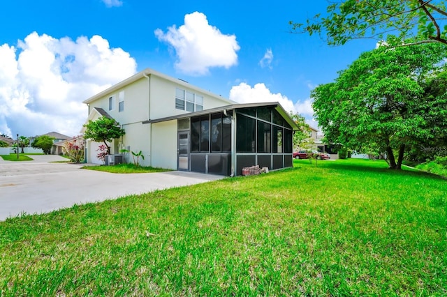 309 Black Springs Ln, Winter Garden, FL 34787 - rear view of house with a sunroom, cooling unit, stucco siding, and a yard