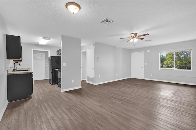 2357 E Dana Dr, Deltona, FL 32738 - unfurnished living room featuring ceiling fan, a sink, dark wood-style flooring, baseboards, and a textured ceiling