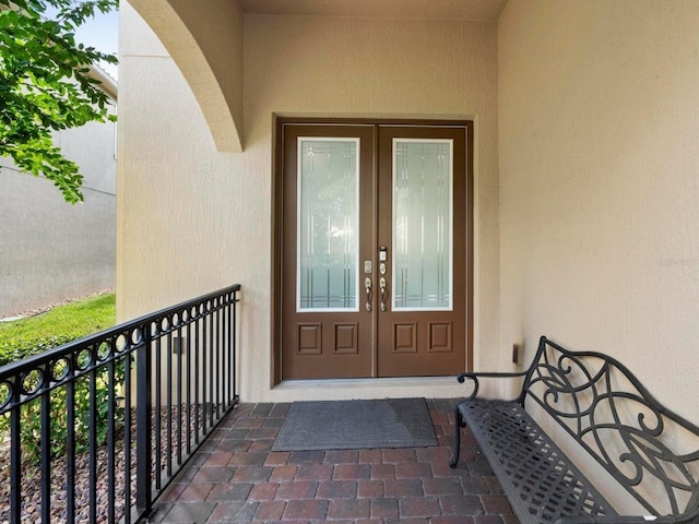 8312 Prestbury Dr, Orlando, FL 32832 - view of exterior entry with french doors, stucco siding, and a balcony