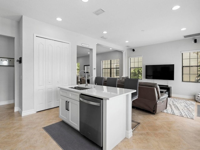 8312 Prestbury Dr, Orlando, FL 32832 - kitchen with stainless steel dishwasher, a sink, a center island with sink, white cabinetry, and recessed lighting