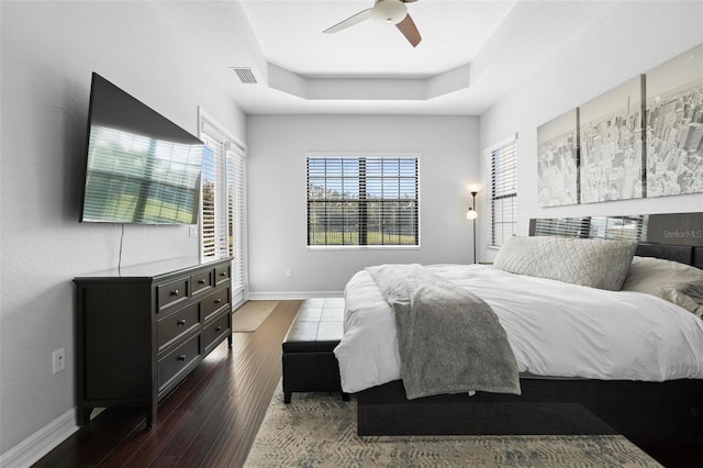 8312 Prestbury Dr, Orlando, FL 32832 - bedroom with dark wood-type flooring, baseboards, ceiling fan, and a tray ceiling