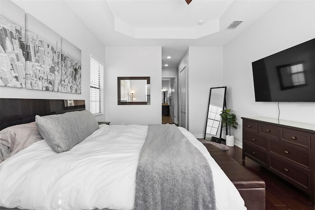 8312 Prestbury Dr, Orlando, FL 32832 - bedroom featuring dark wood-type flooring, recessed lighting, connected bathroom, a tray ceiling, and baseboards
