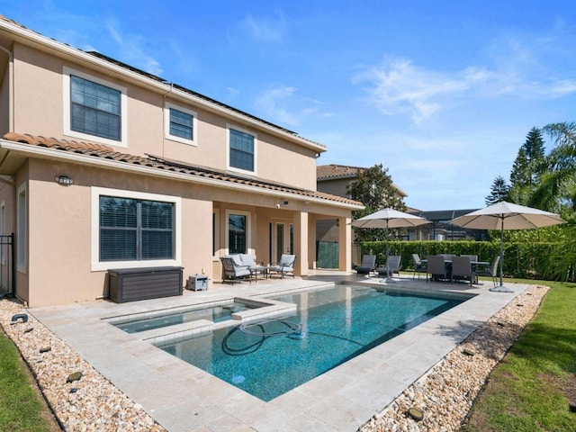 8312 Prestbury Dr, Orlando, FL 32832 - rear view of property featuring a patio, stucco siding, a pool with connected hot tub, and a tiled roof