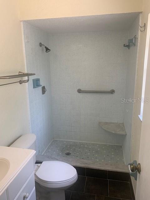 2233 N Normandy Blvd, Deltona, FL 32725 - bathroom featuring toilet, vanity, and a stall shower