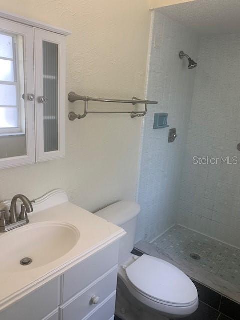 2233 N Normandy Blvd, Deltona, FL 32725 - bathroom featuring a stall shower, toilet, and vanity