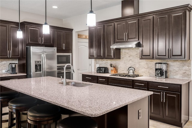 2156 Antilles Club Dr, Kissimmee, FL 34747 - kitchen featuring appliances with stainless steel finishes, under cabinet range hood, a sink, a breakfast bar, and tasteful backsplash