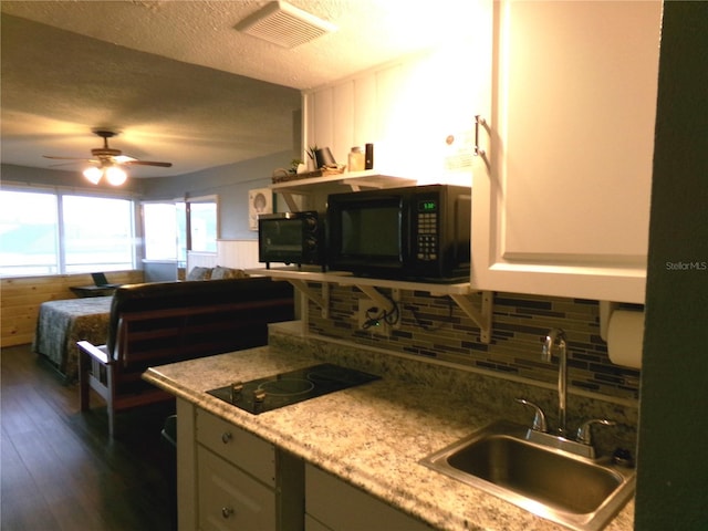 219 S Atlantic Ave Unit 436, Daytona Beach, FL 32118 - kitchen with black appliances, a sink, decorative backsplash, dark wood-type flooring, and a textured ceiling