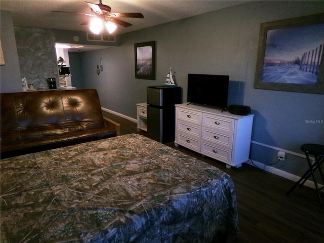 219 S Atlantic Ave Unit 436, Daytona Beach, FL 32118 - bedroom featuring baseboards, dark wood-style flooring, freestanding refrigerator, and a ceiling fan