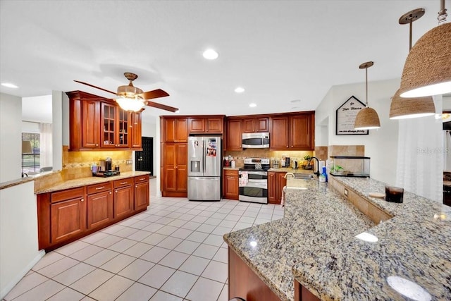 2900 Hammock Dr, Plant City, FL 33566 - kitchen with appliances with stainless steel finishes, a peninsula, backsplash, a ceiling fan, and light tile patterned flooring