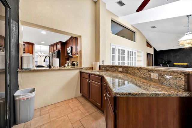 2900 Hammock Dr, Plant City, FL 33566 - kitchen with lofted ceiling, stainless steel microwave, light stone counters, pendant lighting, and fridge