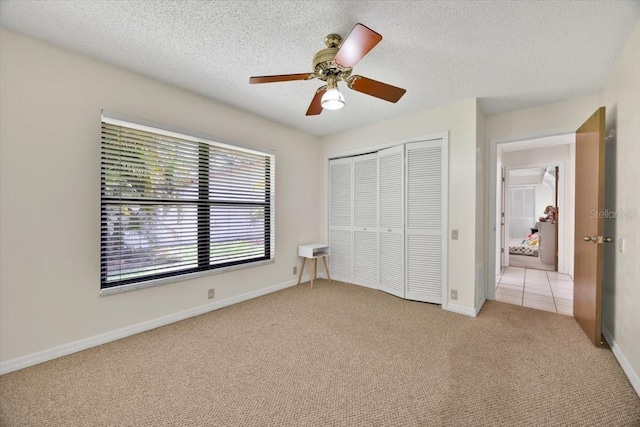 2900 Hammock Dr, Plant City, FL 33566 - unfurnished bedroom with light colored carpet, a closet, a textured ceiling, and a ceiling fan