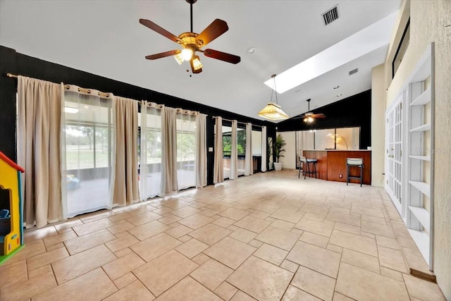 2900 Hammock Dr, Plant City, FL 33566 - unfurnished living room with ceiling fan, stone tile floors, high vaulted ceiling, french doors, and a skylight