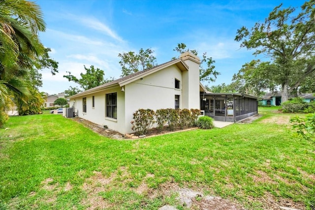 2900 Hammock Dr, Plant City, FL 33566 - rear view of house featuring a sunroom, stucco siding, and a lawn