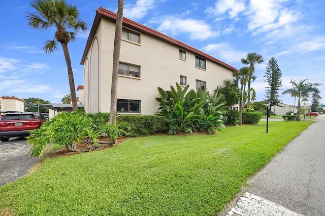 5800 N Banana River Blvd Unit 128, Cape Canaveral, FL 32920 - view of property exterior featuring stucco siding and a lawn