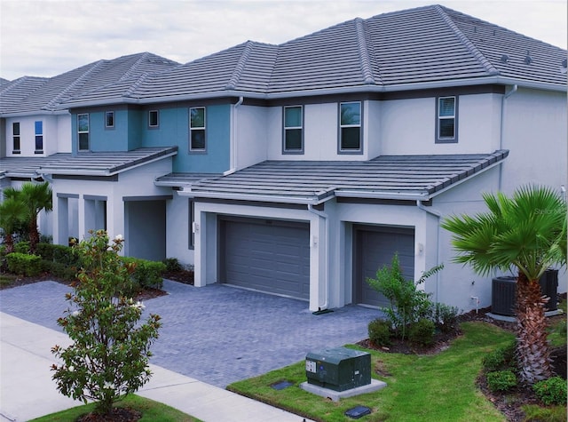 3880 Sonoma Blvd, Kissimmee, FL 34741 - view of front of house featuring an attached garage, a tiled roof, stucco siding, and decorative driveway