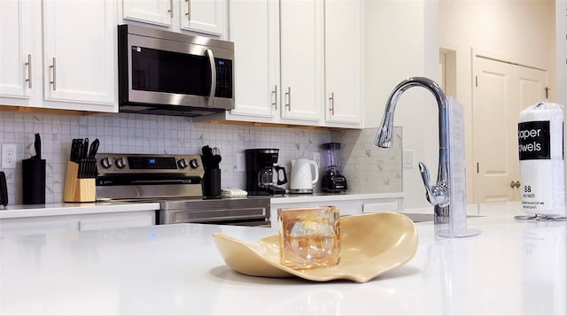 3880 Sonoma Blvd, Kissimmee, FL 34741 - kitchen featuring appliances with stainless steel finishes, white cabinetry, light countertops, and backsplash
