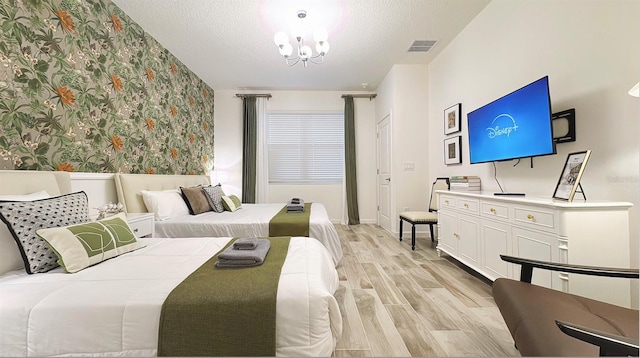3880 Sonoma Blvd, Kissimmee, FL 34741 - bedroom featuring light wood-type flooring, wallpapered walls, a chandelier, a textured ceiling, and baseboards