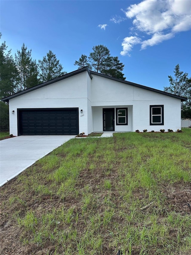 3063 SW 168th Loop, Ocala, FL 34473 - contemporary house with a garage, concrete driveway, stucco siding, and a front yard