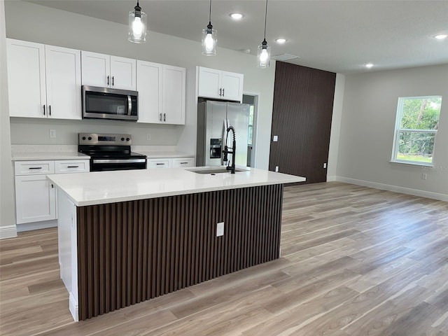 3063 SW 168th Loop, Ocala, FL 34473 - kitchen with stainless steel appliances, a sink, a kitchen island with sink, light countertops, and white cabinets