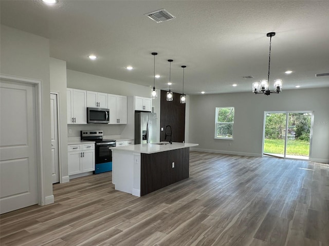 3063 SW 168th Loop, Ocala, FL 34473 - kitchen featuring stainless steel appliances, open floor plan, light wood-style flooring, white cabinetry, and a sink