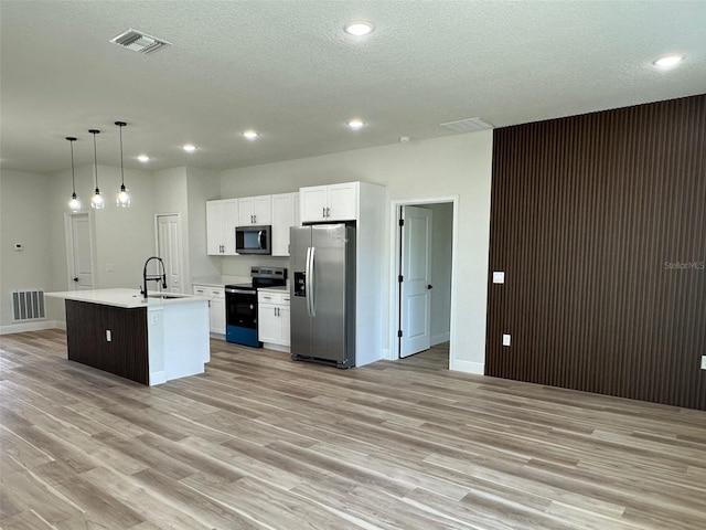 3063 SW 168th Loop, Ocala, FL 34473 - kitchen featuring appliances with stainless steel finishes, a sink, light wood finished floors, recessed lighting, and white cabinets