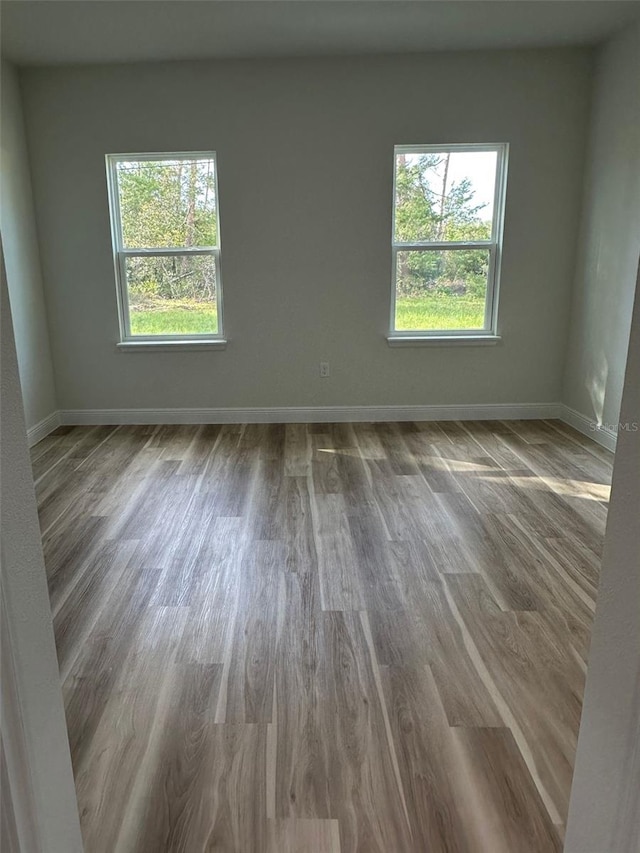3063 SW 168th Loop, Ocala, FL 34473 - unfurnished room featuring healthy amount of natural light, wood finished floors, and baseboards