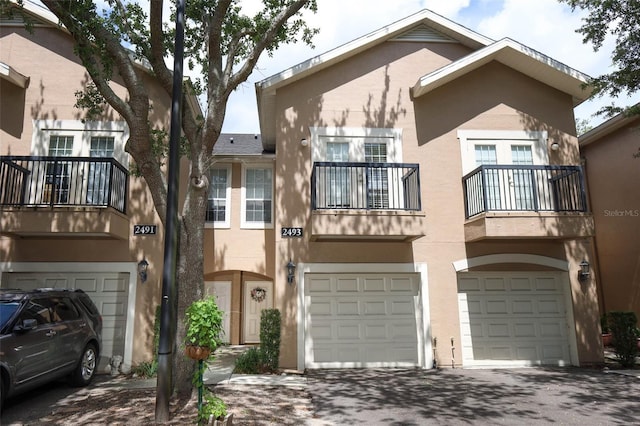 2493 Lancien Ct Unit 5, Orlando, FL 32826 - view of front of property with a garage, driveway, a balcony, and stucco siding