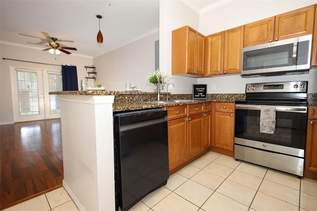 2493 Lancien Ct Unit 5, Orlando, FL 32826 - kitchen featuring stainless steel appliances, crown molding, a ceiling fan, a peninsula, and dark stone counters