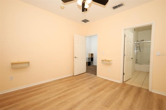 2493 Lancien Ct Unit 5, Orlando, FL 32826 - unfurnished bedroom featuring light wood-style floors, ensuite bathroom, and a ceiling fan