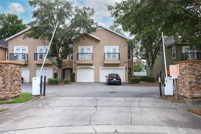 2493 Lancien Ct Unit 5, Orlando, FL 32826 - view of front of property featuring driveway, stucco siding, an attached garage, and a balcony