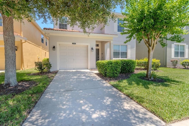 townhome / multi-family property with stucco siding, concrete driveway, a garage, a front yard, and a tiled roof