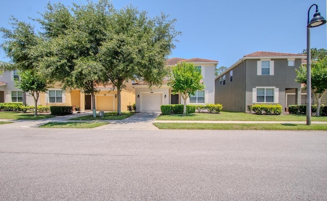 view of front of home featuring concrete driveway, stucco siding, an attached garage, a tiled roof, and a front lawn